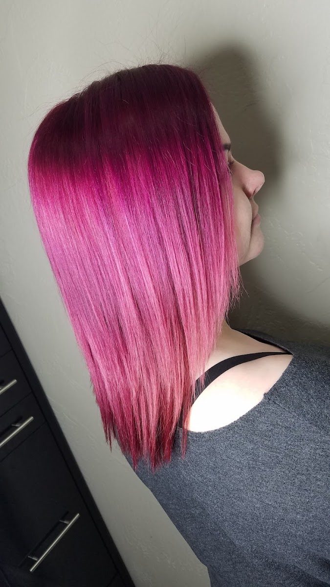 Vivid magenta-pink color on sleek, straight shoulder-length hair